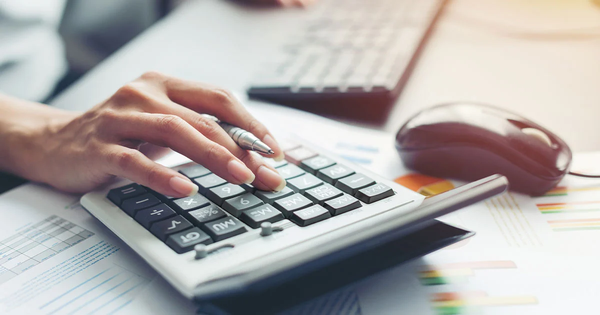 Woman typing on calculator